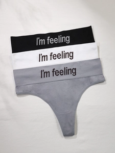 Set of three seamless thong underwear in black, white, and grey with slogan waistbands