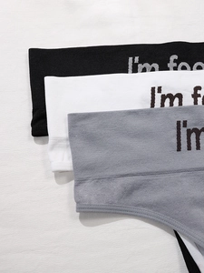 Detailed view of seamless thong panties in black, white, and gray with lettered waistband