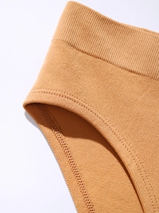 Macro detail of seamless ribbed caramel panty showing fine knitting and reinforced stitching
