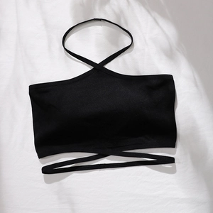 Détail d'un haut licou noir sans couture avec sangles croisées sur fond blanc épuré