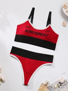 Detail of red and black seamless wireless sports bra set with achievement lettering