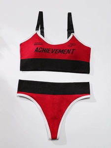Detailed flat lay of red and black seamless wireless sports bra and thong set with lettering