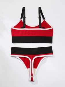 Flat lay of red, black and white color-block sports bra and thong set with adjustable straps