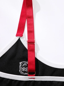 Detail of red adjustable elastic shoulder straps with rose gold buckles on black bra