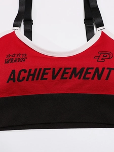 Close-up of color-block sports bra with adjustable straps and achievement logo print