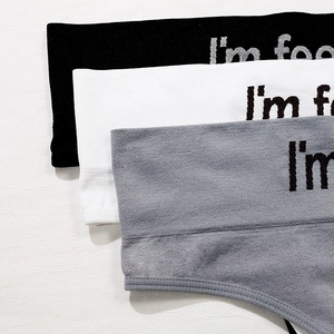 Three-pack seamless thong set in black, white, and gray with metallic slogan waistband