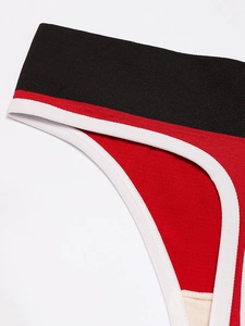 Close-up of seamless red sports briefs featuring black contrast waistband and white piping