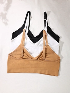 Three-pack seamless sports bras in black, white, and khaki with adjustable straps