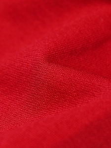 Macro detail of high-density red knitted fabric showing soft seamless texture