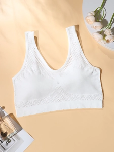 Detail of white seamless sports bra featuring breathable mesh knit and ribbed texture
