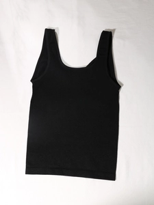 Detail view of the wide elastic waistband and U-neckline on the black shaping vest