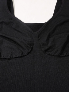 Close-up of black seamless ribbed shapewear vest with V-neckline and ruched chest detail