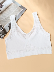 Detail of white seamless sports bra with vertical rib texture and breathable mesh holes
