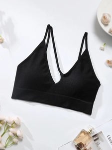 Detail of black ribbed seamless sports bra with double straps and deep V-neckline