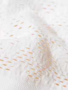 Detail of white hollow breathable fabric with diamond mesh patterns on sports bra
