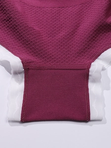 Détail macro du tissu alvéolé respirant et bordure en dentelle sur culotte de maternité