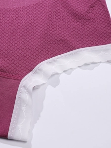 Détail de culotte de maternité rose avec texture nid d'abeille et bordure en dentelle blanche