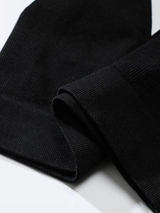 Macro shot of seamless black ribbed knit fabric showing fine texture and elastic weave