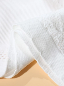 Close-up of white seamless sports bra showing breathable mesh texture and knitted fabric detail
