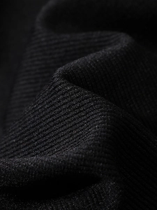 Detailed macro view of black high-density ribbed knit fabric for body shaping vest
