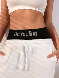 Detail of white ribbed crop top and sweatpants with branded elastic waistband and drawstring