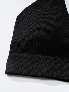 Close-up of black ribbed seamless sports bra featuring wide elastic hem and knit texture