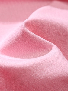 Close-up of pink seamless breathable fabric with fine knitted texture and soft matte finish