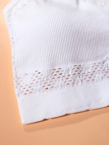 Seamless white sports bra featuring ribbed texture and delicate laser-cut hollow details
