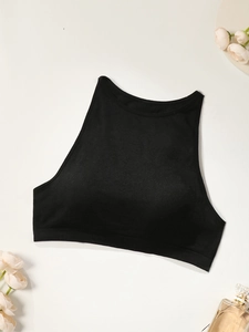 Detailed flat lay of high-strength black sports bra with perfume and floral accents