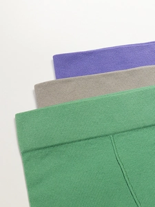 Détail des tailles élastiques en maille côtelée en violet, gris et vert pour shorts yoga
