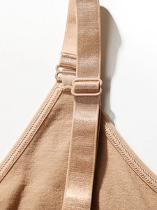 Close-up of adjustable straps and seamless knitted fabric on a beige shapewear vest