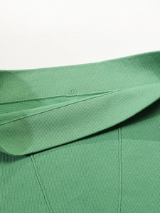 Détail macro du tissu côtelé vert élastique et des coutures plates sur le short de yoga