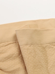 Detailed macro view of beige maternity briefs with honeycomb texture and wide ribbed waistband