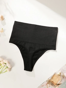 Flat lay of black high-waisted seamless thong for tummy control on marble background