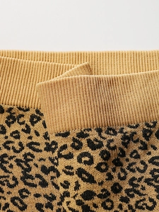Dettaglio del tessuto a maglia leopardato con trama a coste elastica in vita