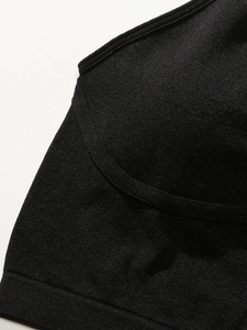 Macro detail of breathable mesh fabric and stitch design on a black sports bra