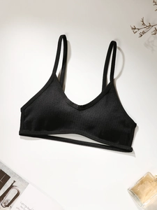 Détail de la brassière de sport côtelée noire avec bretelles fines et bande découpée