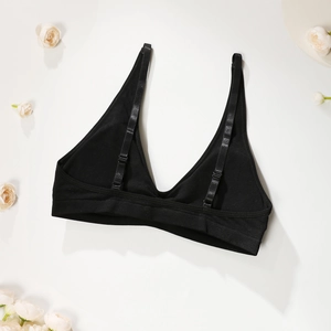 Bralette triangle noire sans couture avec fines bretelles sur des pétales de fleurs