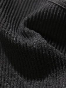 Makro-Detail von schwarzem Rippstrick mit elastischer vertikaler Textur für Yoga-Westen