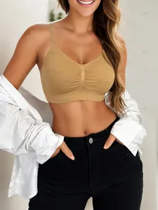 Detail of a seamless earthy brown sports bra with pleated front and slim shoulder straps