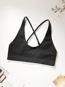 Detail of adjustable cross back straps and ribbed fabric texture on black sports bra