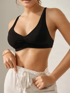 Detail eines schwarzen Sport-BHs mit tiefem V-Ausschnitt, Raffung und glitzerndem Stoff