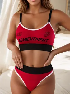 Detailed view of seamless red sports bra set with achievement logo and wide black straps