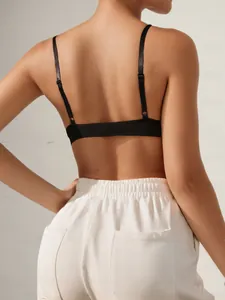 Detail eines schwarzen Sport-BHs mit dünnen Trägern und einer weißen Trainingshose
