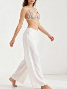 Side view of white high-waisted wide-leg trousers in breathable linen fabric