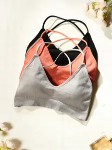 Détail de soutiens-gorge de sport côtelés gris, rose et noir avec dos croisé élégant