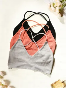 Vue à plat de trois brassières de yoga côtelées en noir, rose et gris à fines bretelles