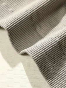 Détail du tissu en maille côtelée grise montrant la haute élasticité et la texture du soutien-gorge