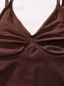 Detail of dark brown seamless bodysuit showing ribbed fabric and ruched V-neckline