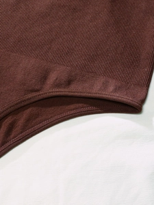 Detailed close-up of dark brown ribbed knit fabric with reinforced double-stitch seams